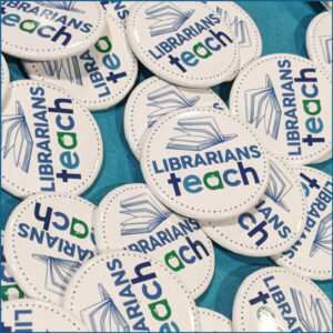 Button pins with Librarians Teach logo scattered on a table.